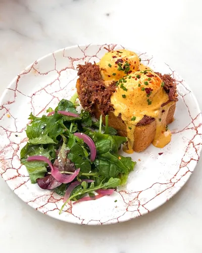 Pulled beef Benedict: brioche, pulled beef and poached eggs, brunch at Oma near République