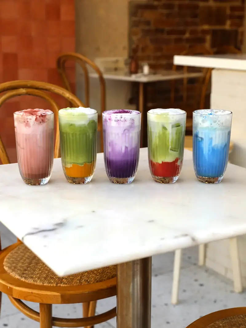 Colourful lattes lined up on a marble table at the Oma coffee shop near République