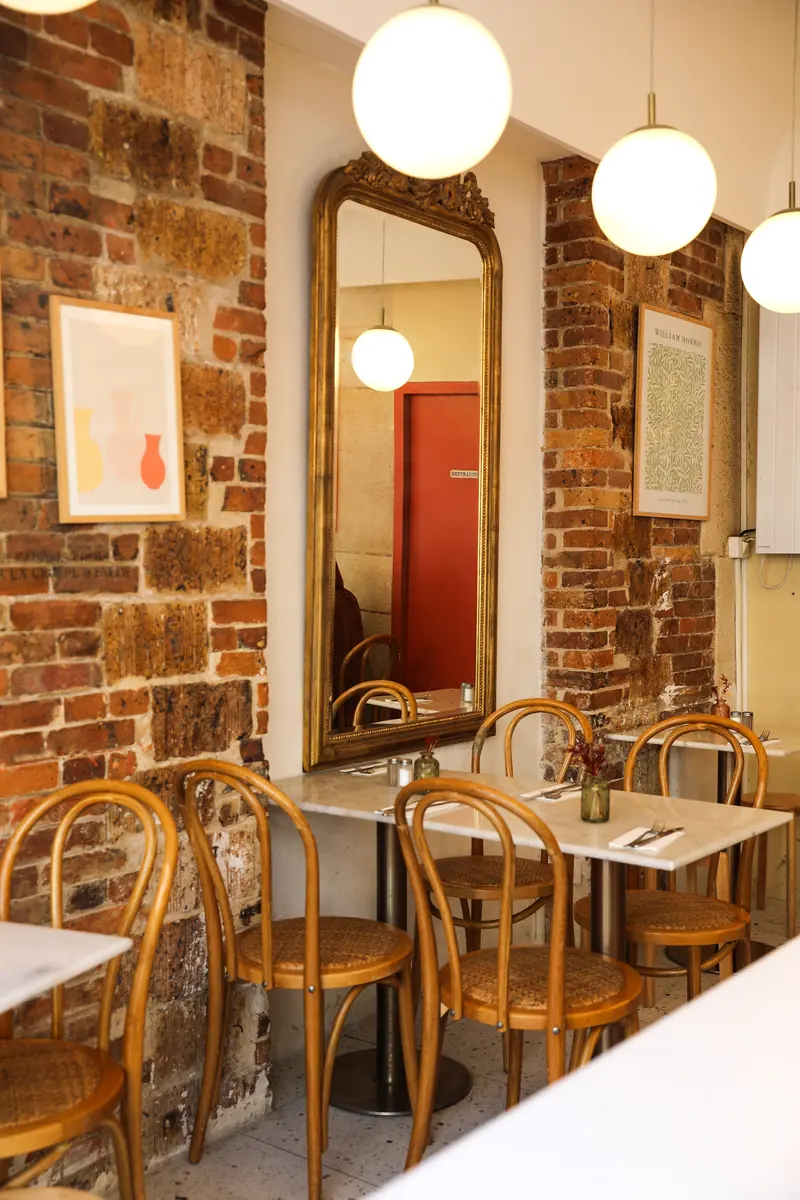 Salle aux murs de briques et chaises bistrot du coffee shop Oma à République